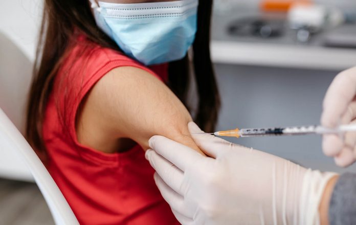 Closeup of girl receiving coronavirus vaccine at doctor's office